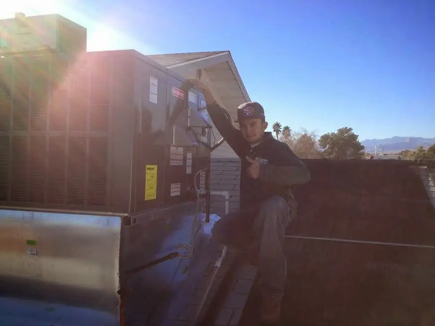 HVAC technician performing Air Duct Repair on a rooftop unit in Garden City